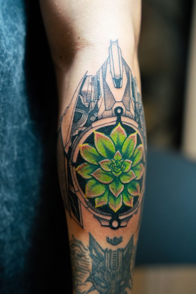 Geometrisches Mandala-Tattoo mit einer grünen Blume in der Mitte an einer Wade
